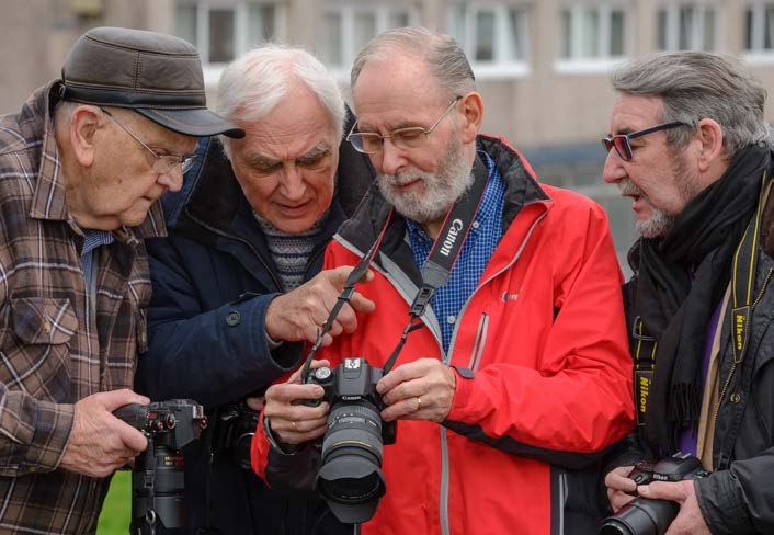 Four older men with cameras